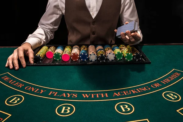 Nahaufnahme des Holdem Dealers mit Spielkarten und Chips auf grünem Tisch — Stockfoto