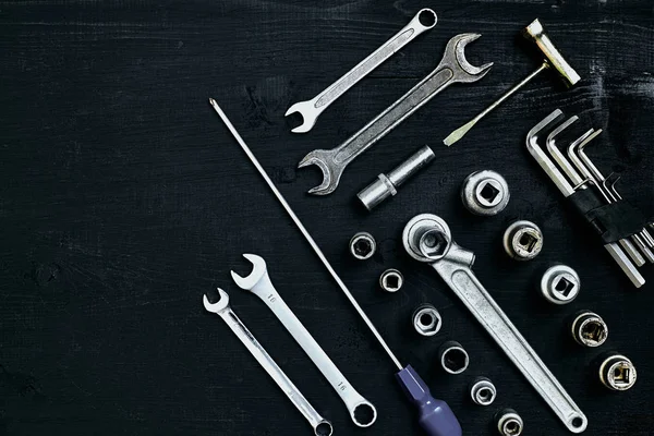 Set of hand bunch of tools in the garage on black wooden background