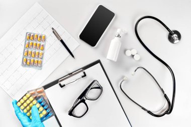 İşyeri bir doktor. Elinde, stetoskop, Pano ve beyaz masa gözlük hap