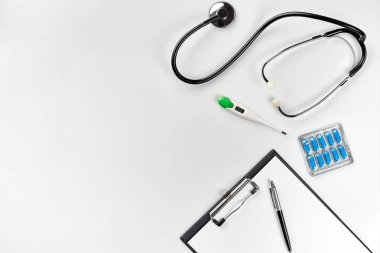 Stetoskop doktor ofisinde. Üstten Görünüm doktorlar Resepsiyon tablo, boş kağıt kalem ile Pano üzerinde. Uzay kopyalayın. Tasarımcılar boş