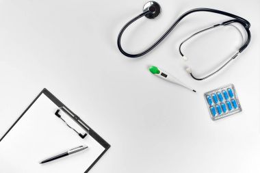 Stetoskop doktor ofisinde. Üstten Görünüm doktorlar Resepsiyon tablo, boş kağıt kalem ile Pano üzerinde. Uzay kopyalayın. Tasarımcılar boş