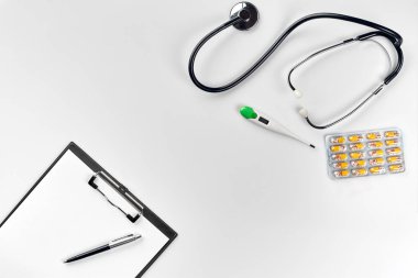 Stetoskop doktor ofisinde. Üstten Görünüm doktorlar Resepsiyon tablo, boş kağıt kalem ile Pano üzerinde. Uzay kopyalayın. Tasarımcılar boş