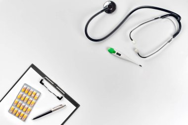 Stetoskop doktor ofisinde. Üstten Görünüm doktorlar Resepsiyon tablo, boş kağıt kalem ile Pano üzerinde. Uzay kopyalayın. Tasarımcılar boş