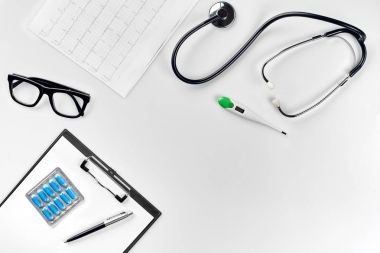 Stetoskop doktor ofisinde. Üstten Görünüm doktorlar Resepsiyon tablo, boş kağıt kalem ile Pano üzerinde. Uzay kopyalayın. Tasarımcılar boş