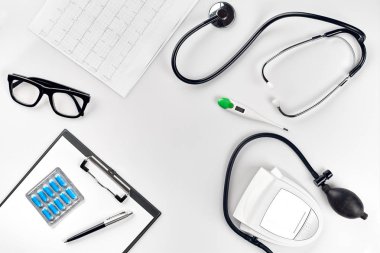 Stetoskop doktor ofisinde. Üstten Görünüm doktorlar Resepsiyon tablo, boş kağıt kalem ile Pano üzerinde. Uzay kopyalayın. Tasarımcılar boş