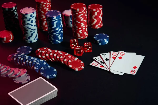 Casino chips and cards on black table surface. Gambling, fortune, game and entertainment concept - close up — Stock Photo, Image