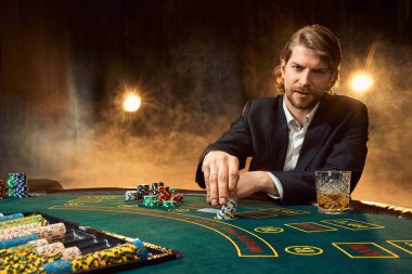 Oyun masada oturan iş elbiseli bir adam. Erkek oyuncu. Tutku, kartları, cips, alkol, kumar, casino - zar, o erkek eğlence 's.