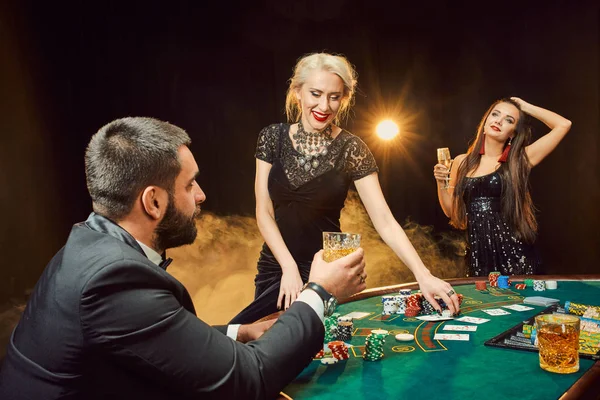 Skupina mladých bohatých lidí hraje poker v kasinu — Stock fotografie