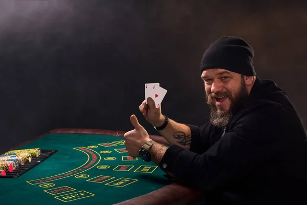 El hombre está jugando póquer. Emocional jugador de cartas ganar en el juego, hombre muy feliz con la toma de decisiones correctas, ganar todas las fichas en el banco . — Foto de Stock