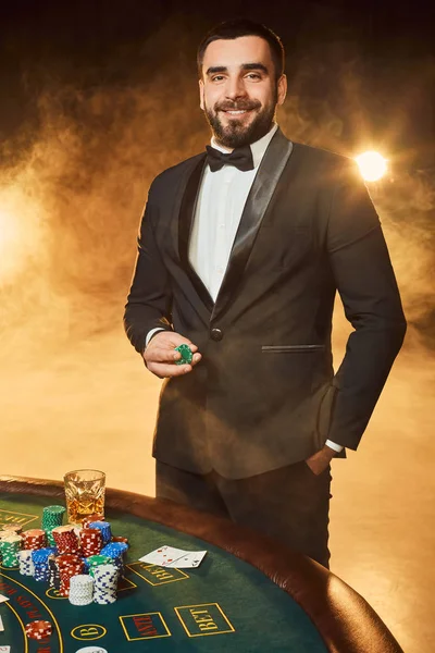 Poker masasında duran iş elbiseli bir genç adam. Adam sakınacak.