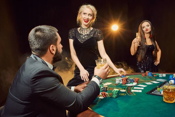 Skupina mladých bohatých lidí hraje poker v kasinu — Stock fotografie