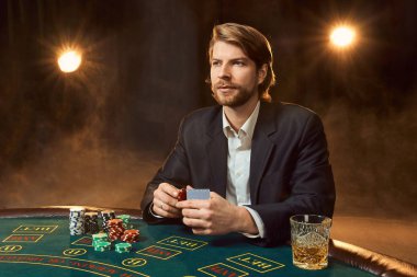 Oyun masada oturan iş elbiseli bir adam. Erkek oyuncu. Tutku, kartları, cips, alkol, kumar, casino - zar, o erkek eğlence 's.