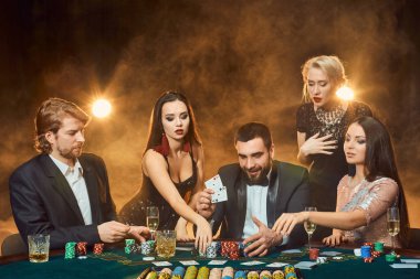 bir kumarhanede bir masa etrafında oturup poker oyuncuları.