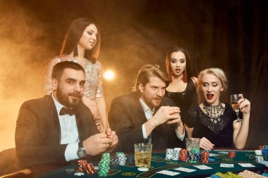 bir kumarhanede bir masa etrafında oturup poker oyuncuları.