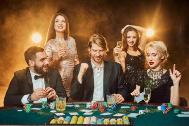 bir kumarhanede bir masa etrafında oturup poker oyuncuları.