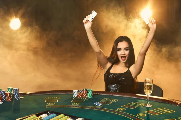 Ursnygg ung kvinna sitter vid pokerbordet med glas champagne — Stockfoto