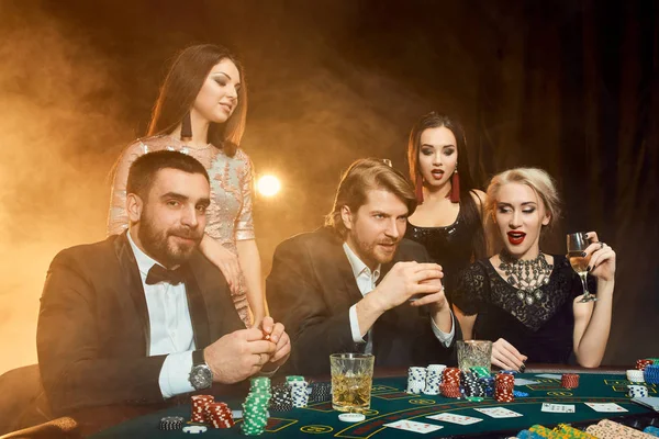 Pokerspelers zitten rond een tafel in een casino. — Stockfoto