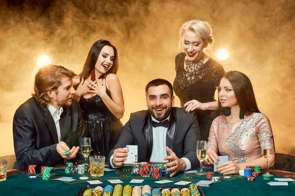 Jugadores de poker sentados alrededor de una mesa en un casino . —  Fotos de Stock
