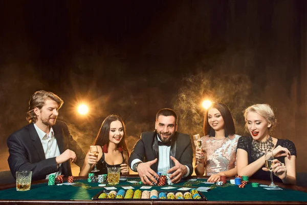 Πόκερ παίκτες που κάθονται γύρω από ένα τραπέζι σε μια χαρτοπαικτική λέσχη. — Φωτογραφία Αρχείου