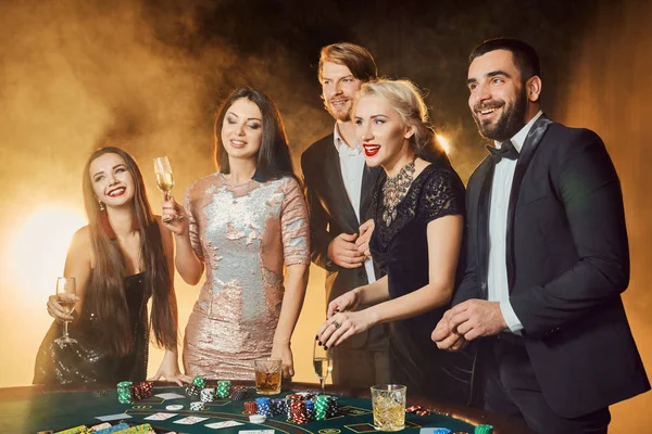 Skupina šťastných lidí během oslav je pití šumivého vína v kasinu — Stock fotografie