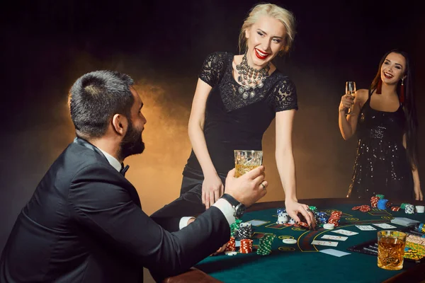 Group of young rich people is playing poker in the casino