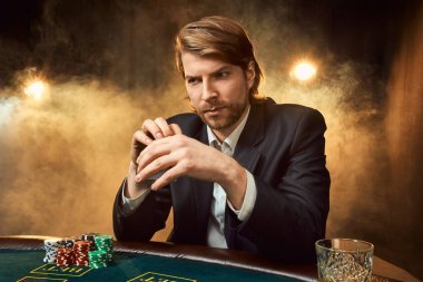 Oyun masada oturan iş elbiseli bir adam. Erkek oyuncu. Tutku, kartları, cips, alkol, kumar, casino - zar, o erkek eğlence 's.