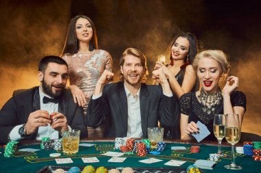 bir kumarhanede bir masa etrafında oturup poker oyuncuları.