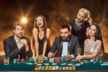 bir kumarhanede bir masa etrafında oturup poker oyuncuları.