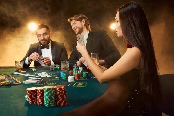 Skupina mladých bohatých lidí hraje poker v kasinu — Stock fotografie