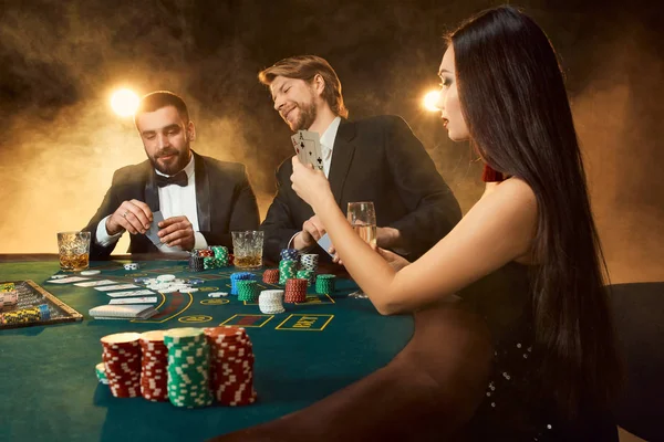 Grupo de jóvenes ricos está jugando al poker en el casino — Foto de Stock