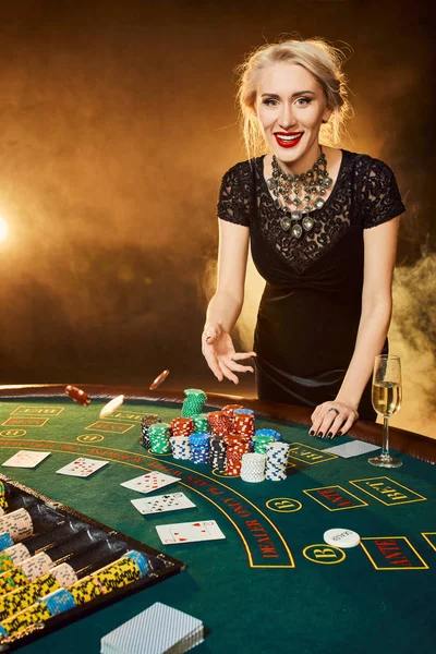 カジノのテーブルでのポーカー チップを投げる女性の肖像 — ストック写真