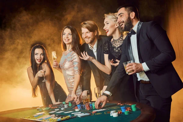 Group of happy people during celebration is drinking sparkling wine in the casino — Stock Photo, Image