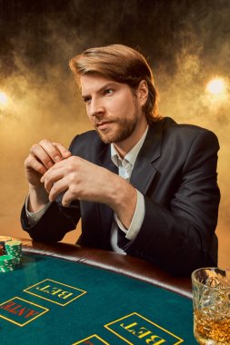 Oyun masada oturan iş elbiseli bir adam. Erkek oyuncu. Tutku, kartları, cips, alkol, kumar, casino - zar, o erkek eğlence 's.