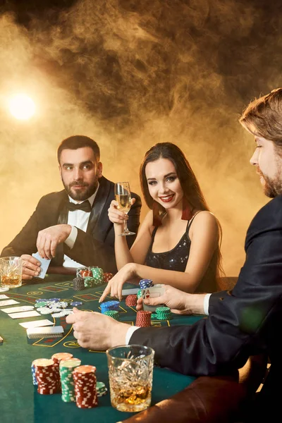 Skupina mladých bohatých lidí hraje poker v kasinu — Stock fotografie