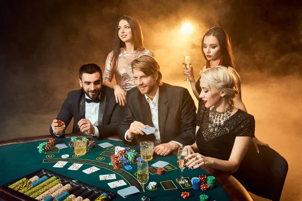 Pokerspelers zitten rond een tafel in een casino. — Stockfoto