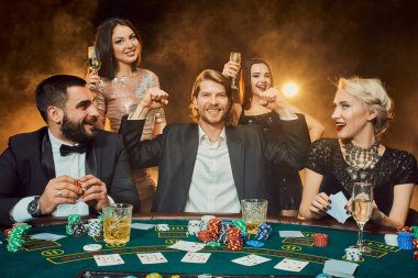 bir kumarhanede bir masa etrafında oturup poker oyuncuları.