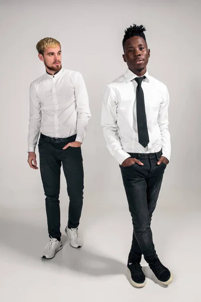 Internationale vriendschap concept. Studio shot van twee stijlvolle jonge mannen op witte achtergrond — Stockfoto
