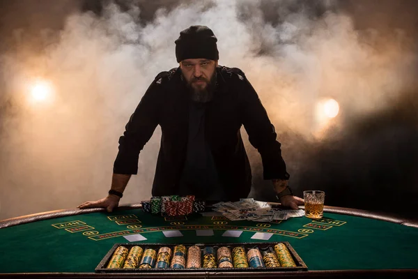 Male gambler playing poker, smoke dark color intensity.