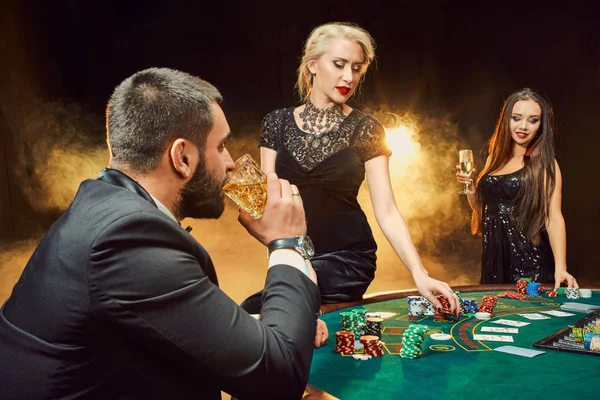 Grupo de jóvenes ricos está jugando al poker en el casino — Foto de Stock