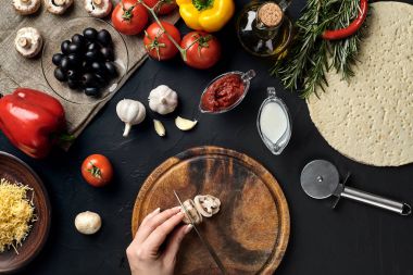 El ahşap tahta mutfak masa etrafında yalan malzemeler için pizza üzerinde mantar kes: sebze, peynir ve baharatlar.