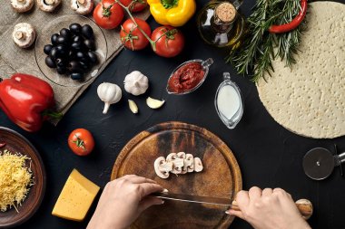 El ahşap tahta mutfak masa etrafında yalan malzemeler için pizza üzerinde mantar kes: sebze, peynir ve baharatlar.