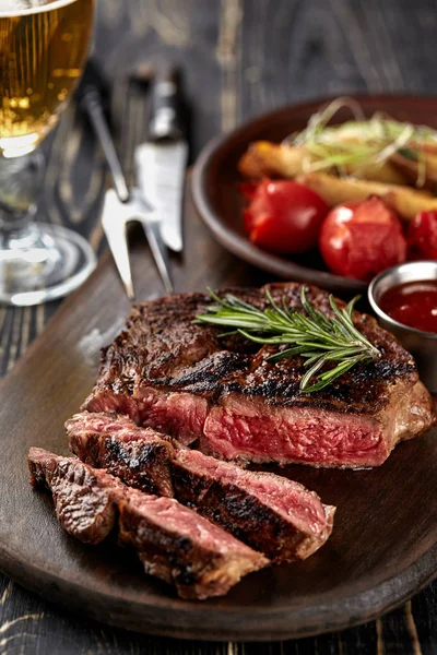 Bife suculento carne rara média com especiarias em tábua de madeira na mesa — Fotografia de Stock