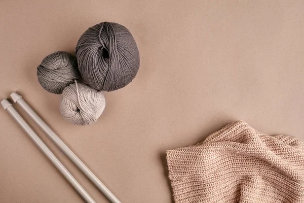 Tricoté à partir d'un pull en fil gris et fil pour tricoter en gros plan. Tricoter comme passe-temps. Accessoires pour tricot . — Photo