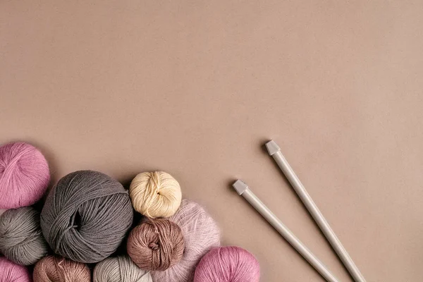 Un groupe de boules colorées de fils et aiguilles à tricoter sur fond beige — Photo