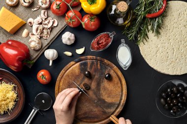 El Ahşap mutfak masa etrafında yalan malzemeler pizza için tahtada zeytin kes: sebze, peynir ve baharatlar.