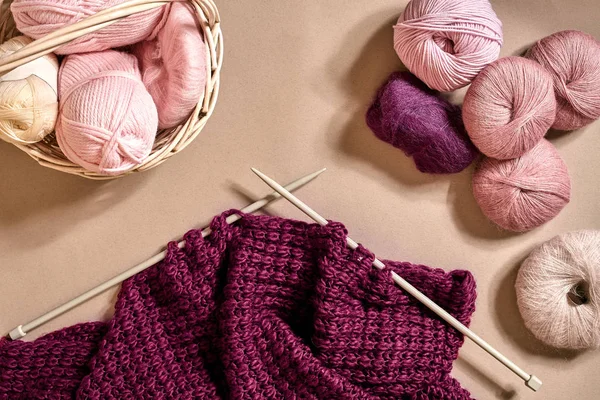 Palle di filato di lana merino, lavorare a maglia su ferri da maglia su una superficie beige. Vista dall'alto — Foto Stock