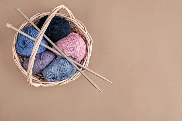 Fil de différentes couleurs dans le panier avec des aiguilles à tricoter. Vue du dessus — Photo
