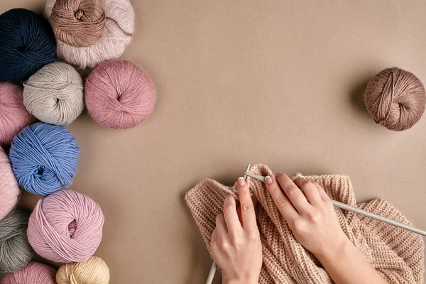 Primo piano di maglione di lana lavorante a maglia di mani femminili o colore beige plaid. Vista dall'alto — Foto Stock