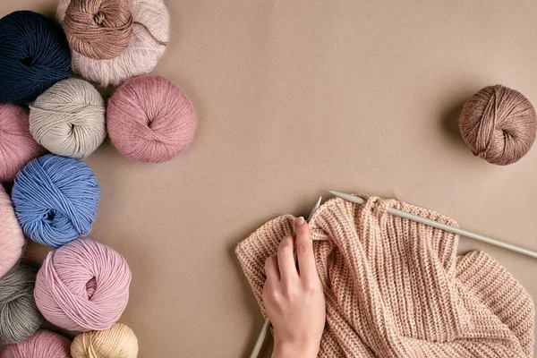 Primo piano di maglione di lana lavorante a maglia di mani femminili o colore beige plaid. Vista dall'alto — Foto Stock