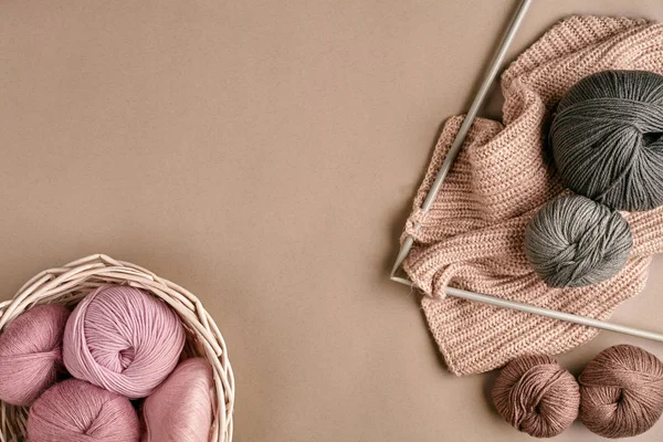 Palle di filato di lana merino, lavorare a maglia su ferri da maglia su una superficie beige. Vista dall'alto — Foto Stock